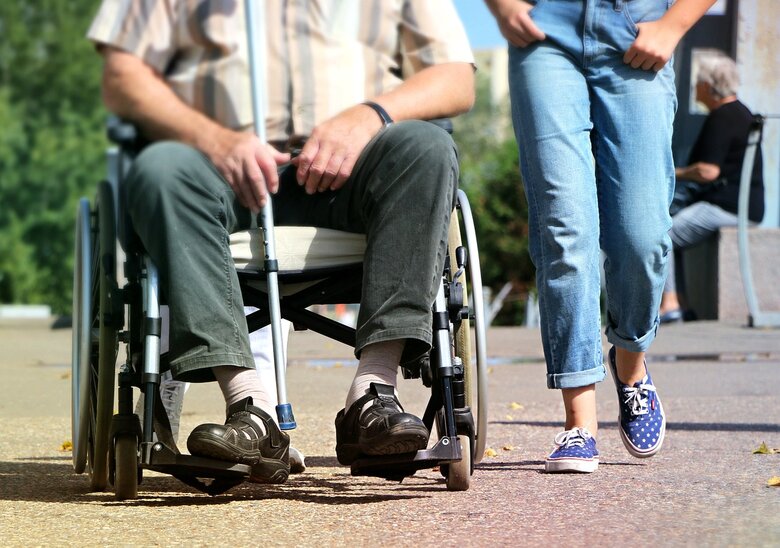 Semaine du Cerveau 2024 Une personne en chaise roulante se déplace avec une autre personne