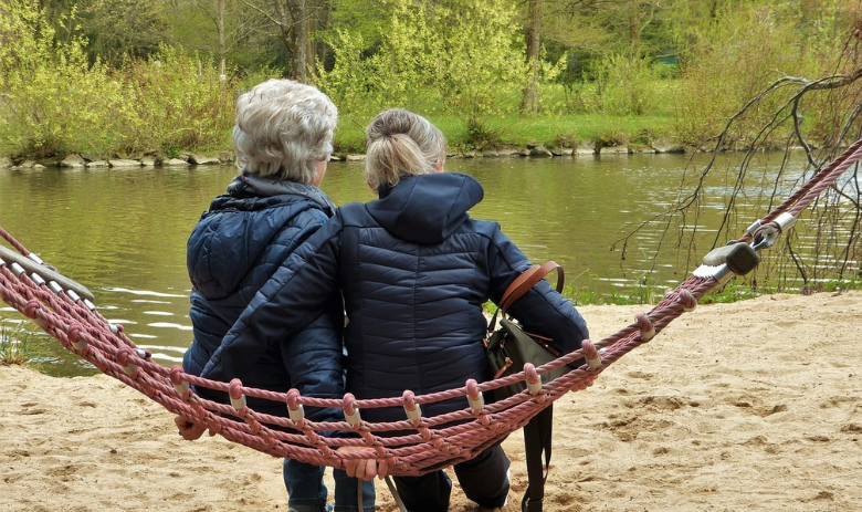 Kurse Zwei Frauen sitzen nebeneinander auf einer Hängematte